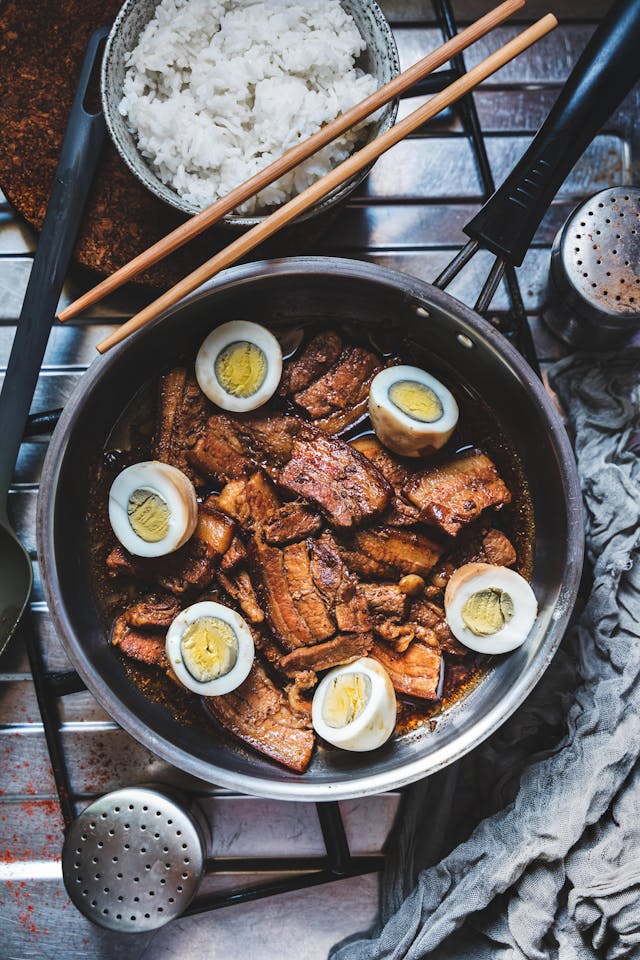 Mouthwatering Pork Adobo with Eggs Beside the Bowl of Rice