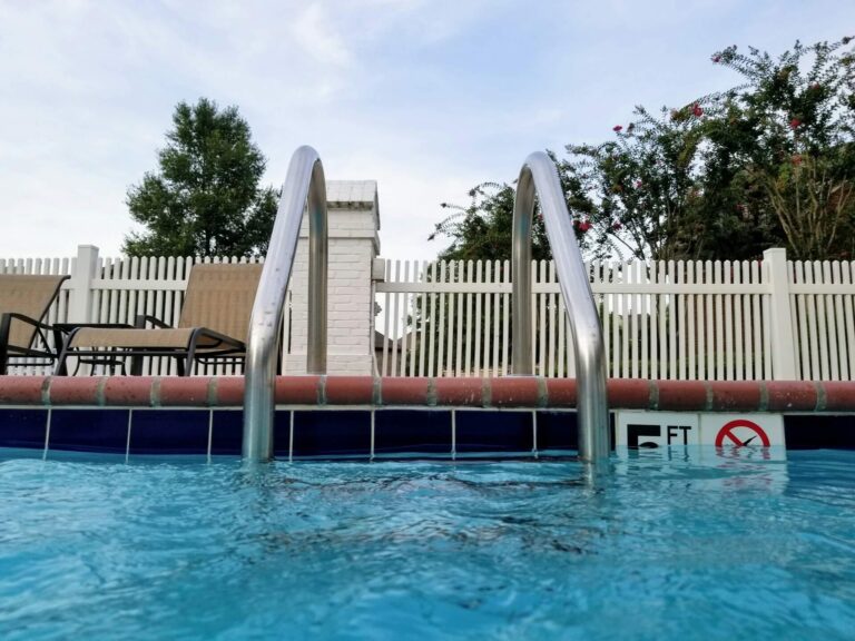 Outdoor pool with hand rails enclosed with fence