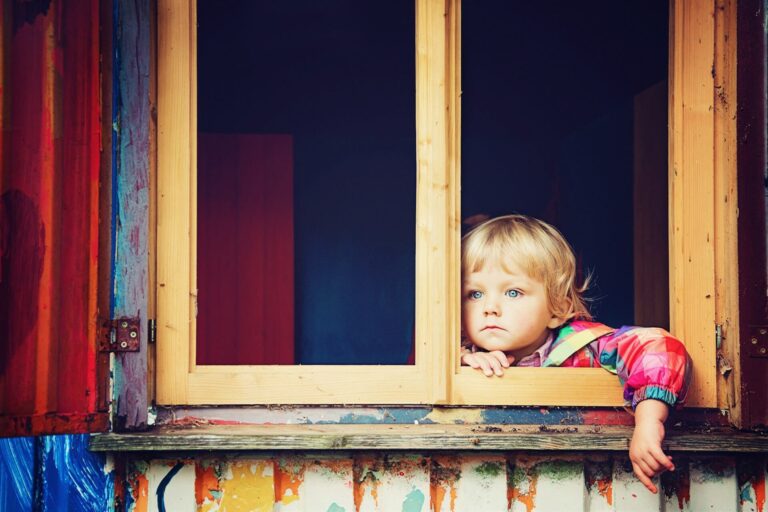 Child looking out a window that is not child-locked