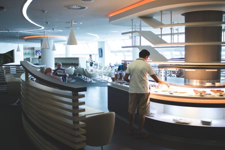 Sleek airport lounge with man serving from buffet